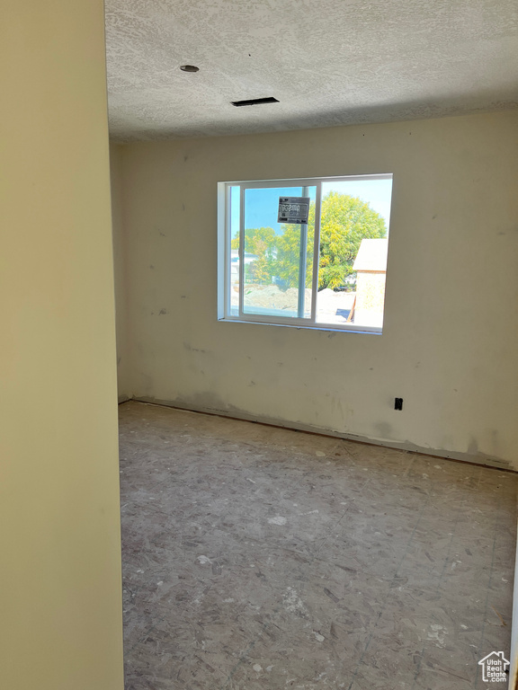 Unfurnished room with a textured ceiling