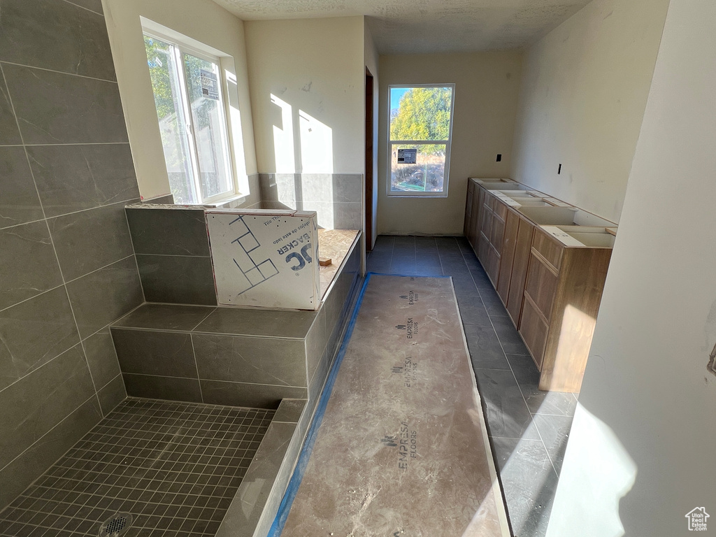 Bathroom with vanity, tile patterned floors, and a textured ceiling