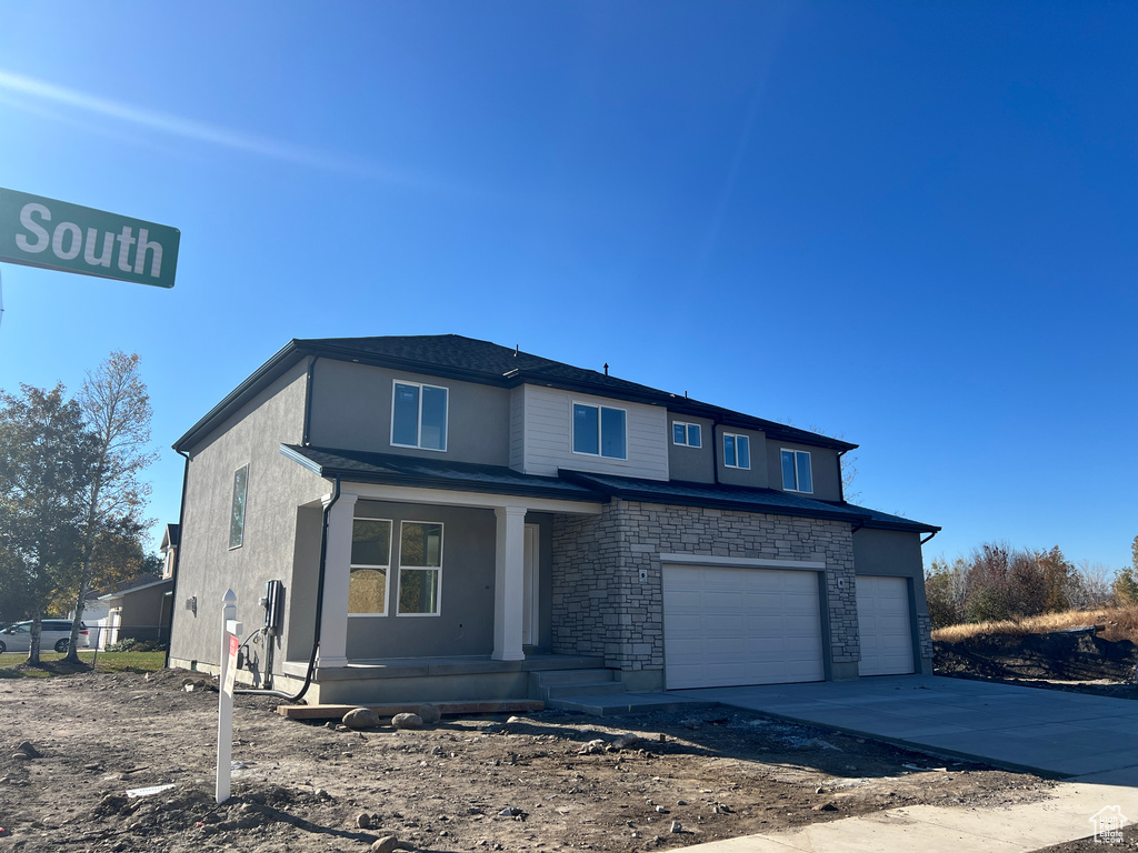 View of front of home featuring a garage and a porch