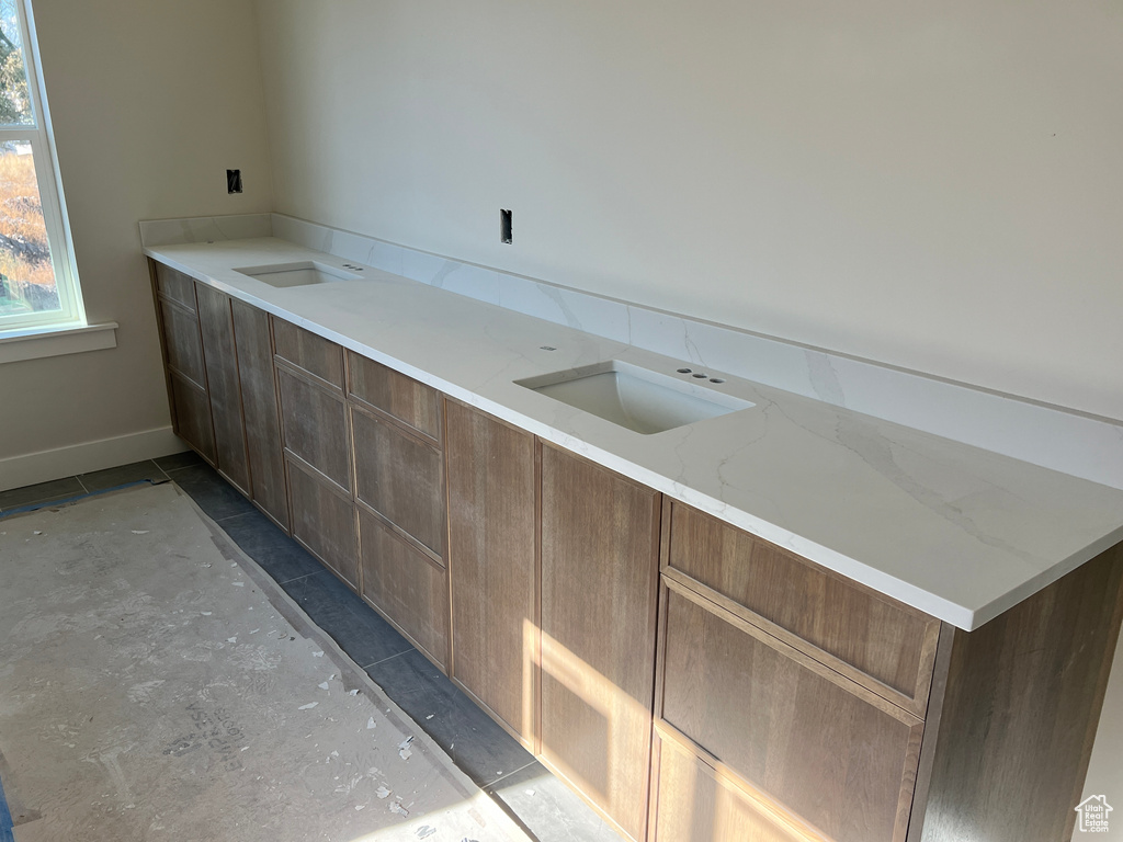 Kitchen featuring light stone countertops and sink