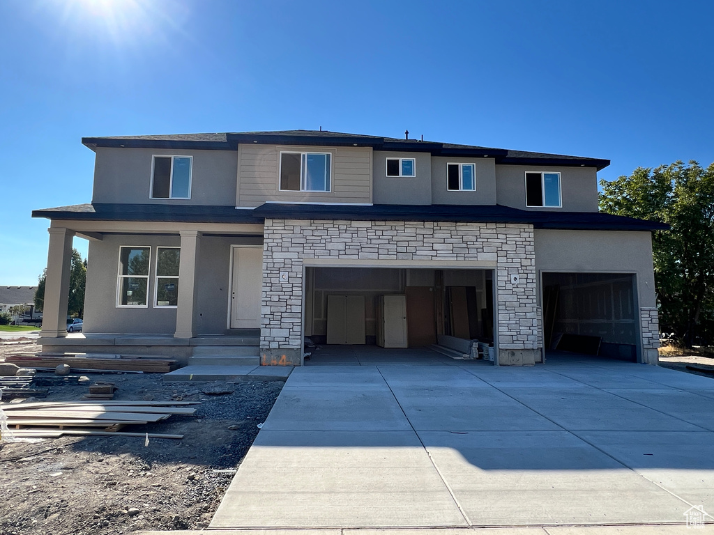 View of front of house featuring a garage and a porch