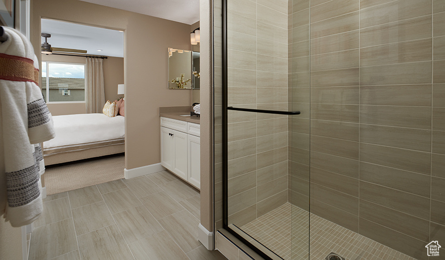 Bathroom featuring tile patterned flooring, a shower with door, ceiling fan, and vanity