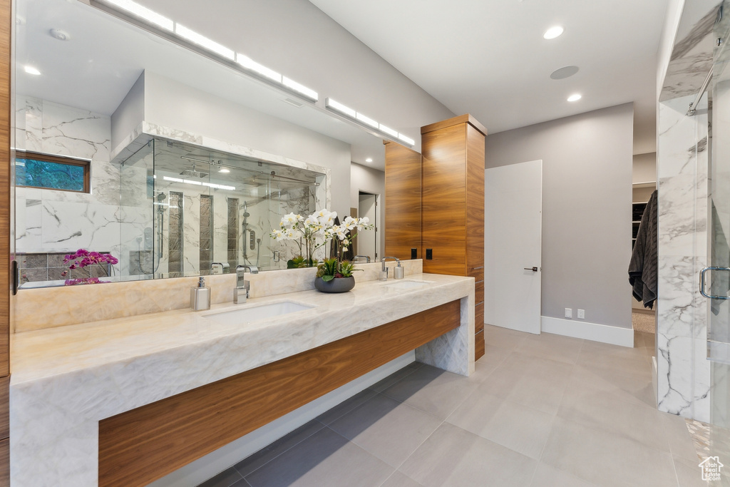 Bathroom featuring walk in shower, dual bowl vanity, and tile patterned flooring