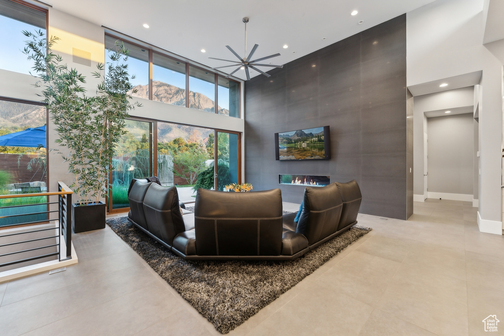 Tiled living room featuring a high ceiling and an inviting chandelier