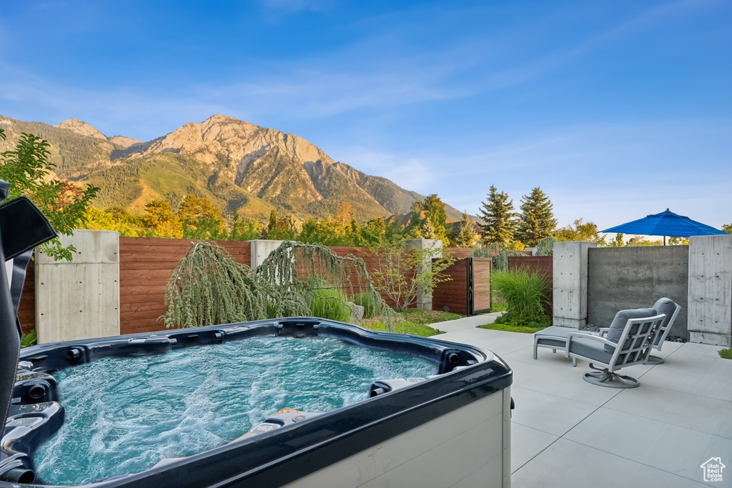 View of pool featuring a mountain view, a hot tub, and a patio