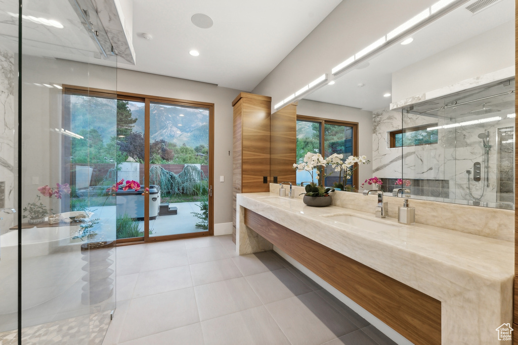 Bathroom with a shower with door, dual bowl vanity, and tile patterned flooring