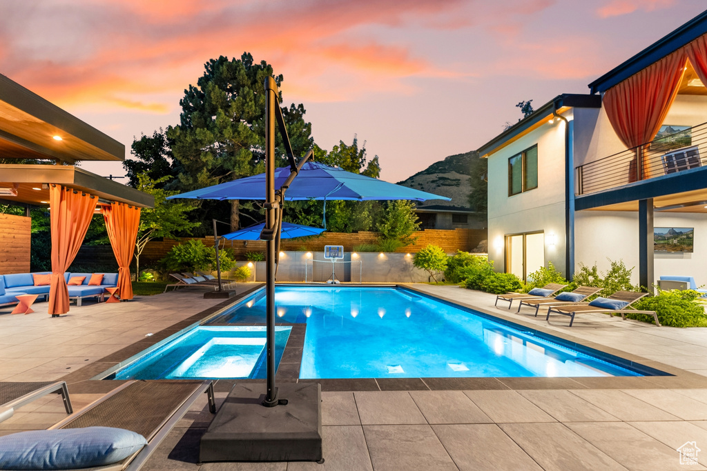 Pool at dusk featuring a patio