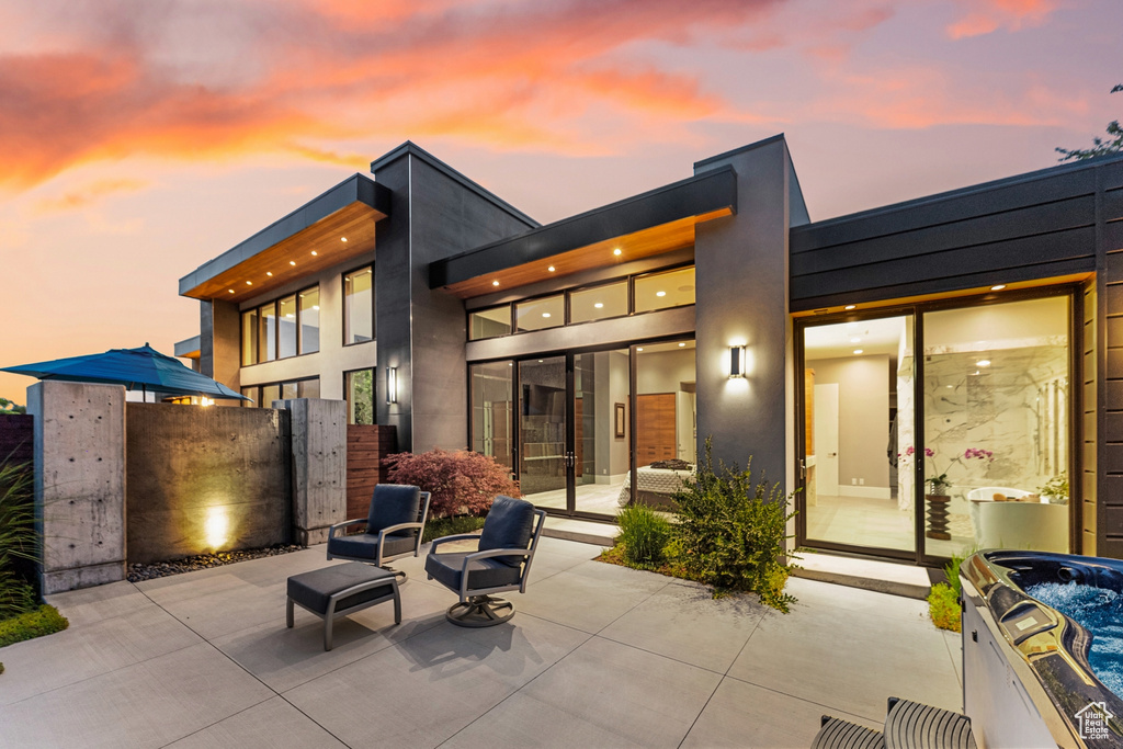 Back house at dusk featuring a patio area