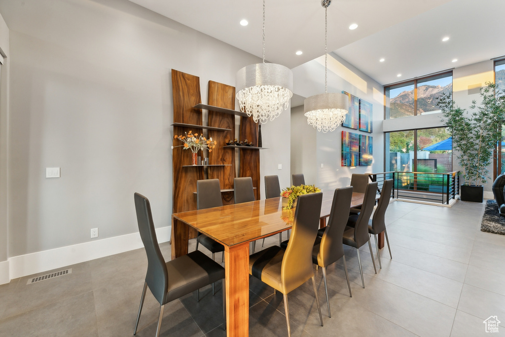 Tiled dining space with expansive windows and a chandelier