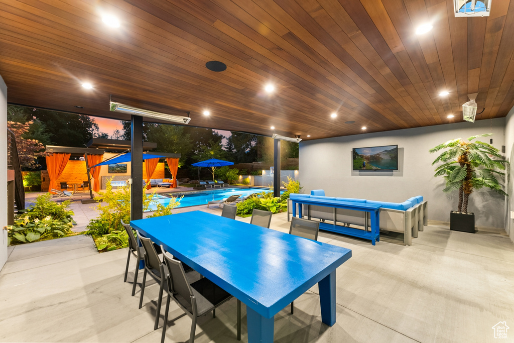 Recreation room featuring light tile patterned floors, a wall of windows, and wood ceiling