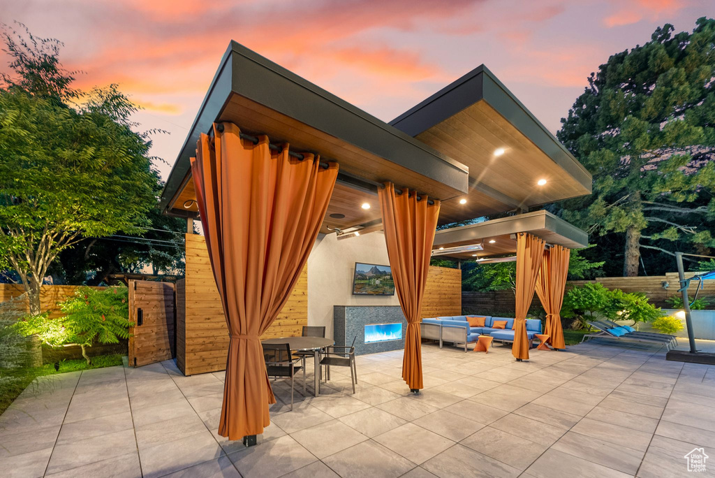 Patio terrace at dusk featuring outdoor lounge area