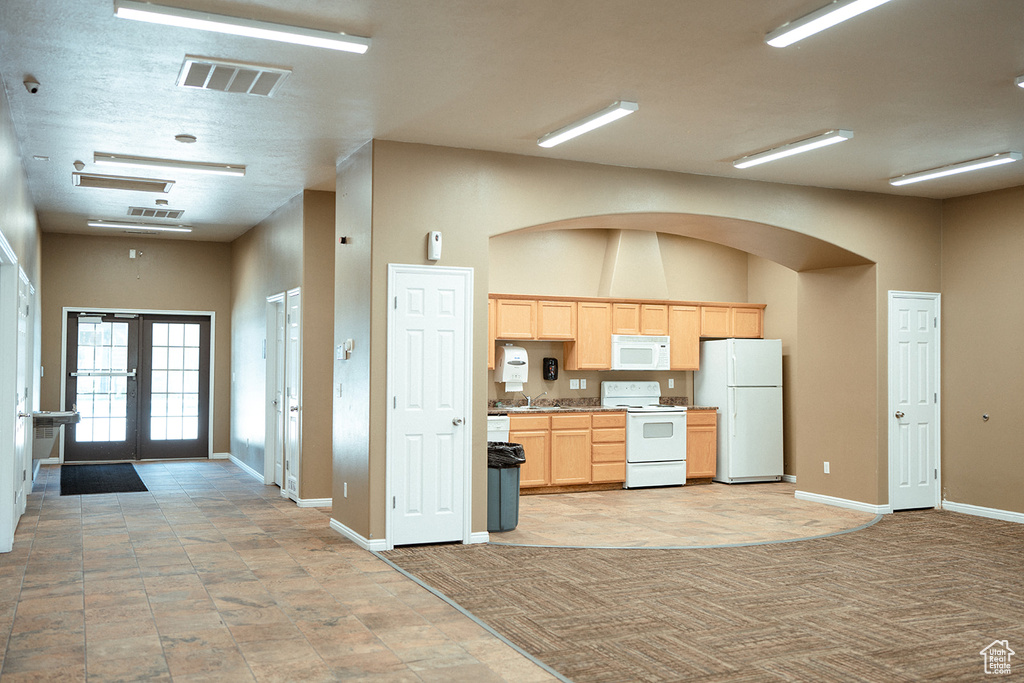 Kitchen featuring light brown cabinetry, french doors, white appliances, and light tile patterned floors