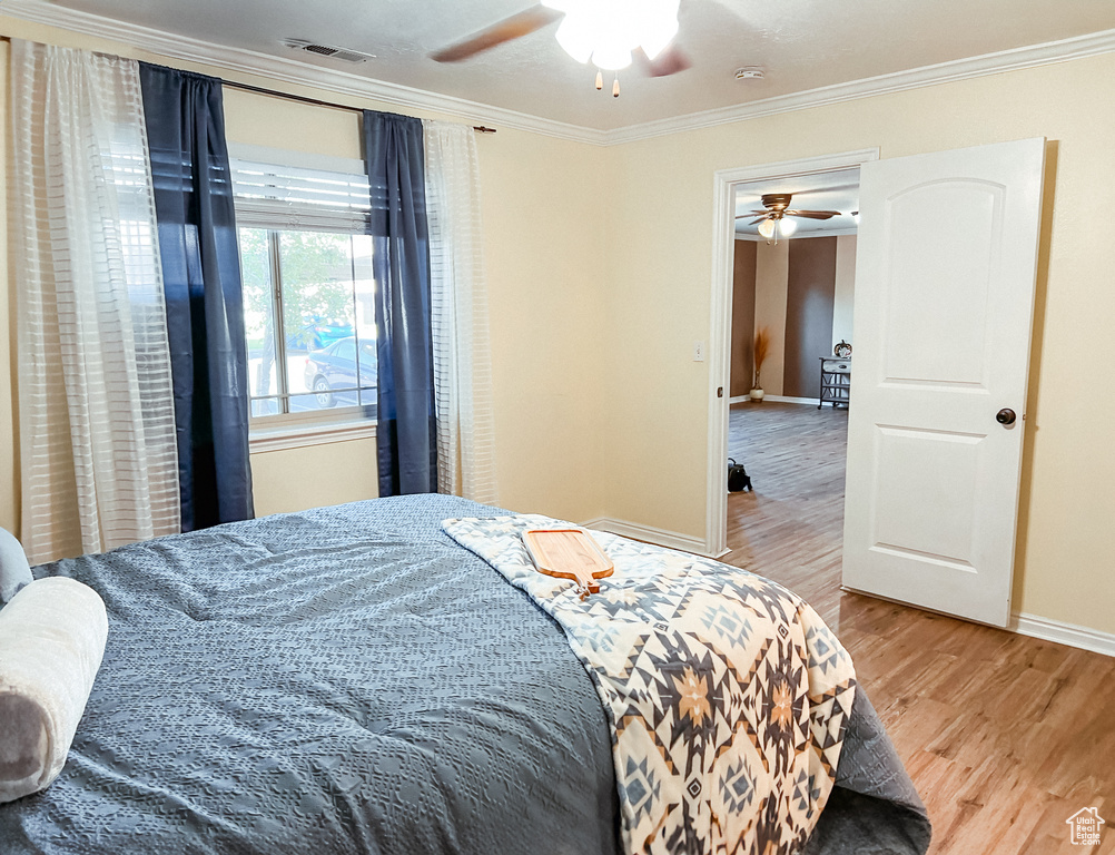 Bedroom featuring ceiling fan, light hardwood / wood-style floors, and ornamental molding