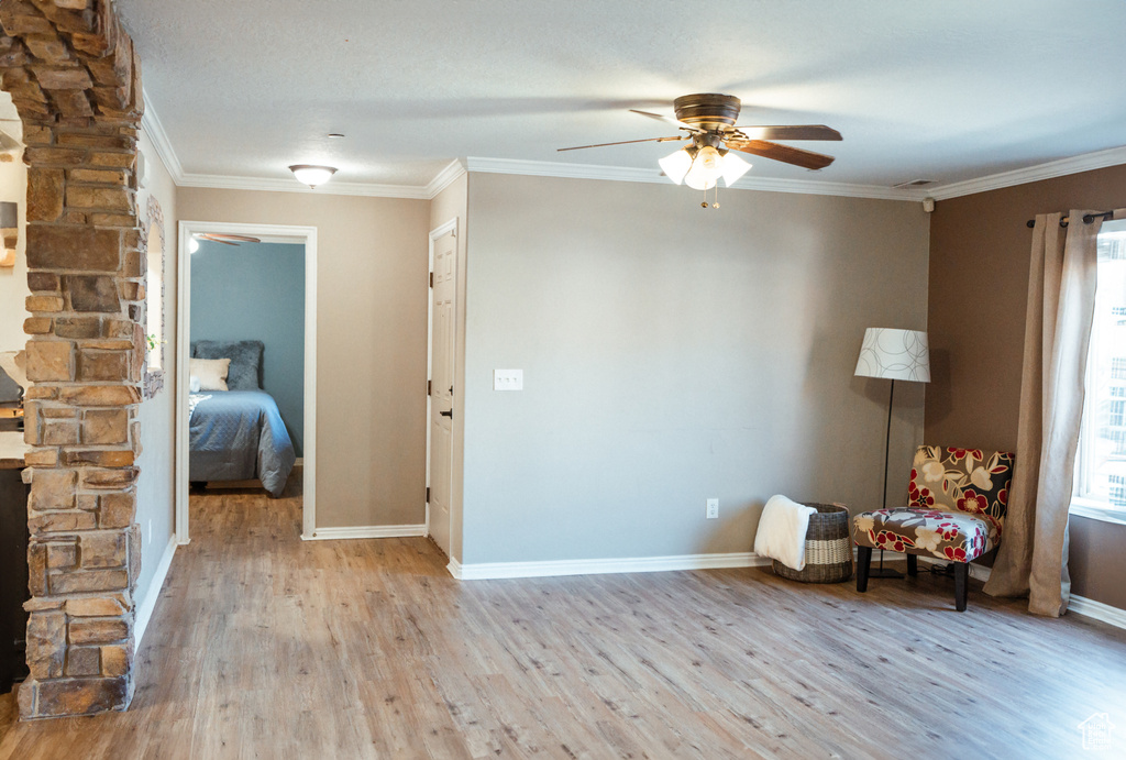 Unfurnished room with light wood-type flooring, ornamental molding, and ceiling fan