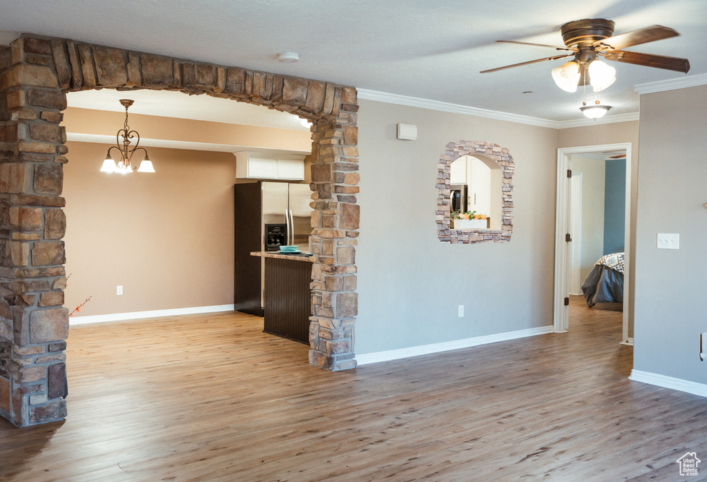 Empty room with ornamental molding, hardwood / wood-style flooring, and ceiling fan