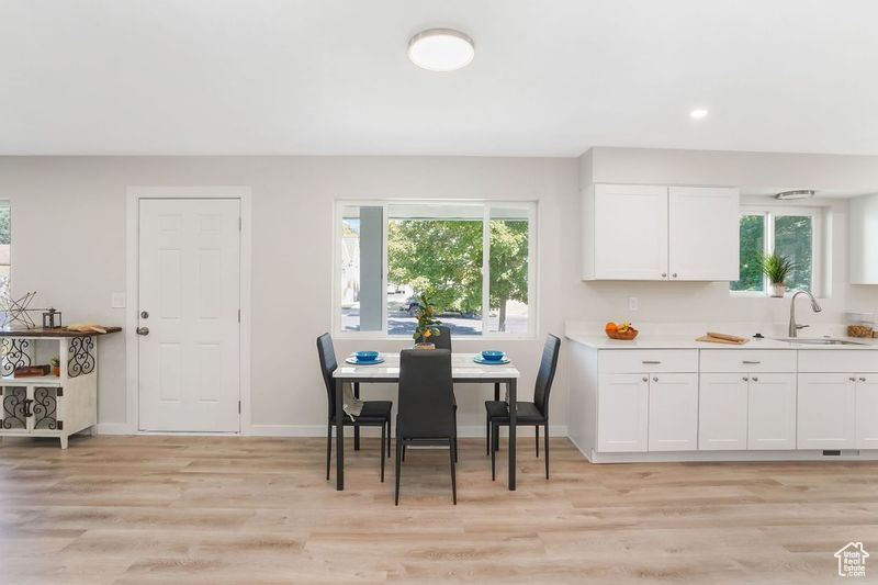 Dining room with a wealth of natural light, sink, and light hardwood / wood-style flooring