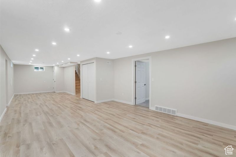 Basement with light hardwood / wood-style floors