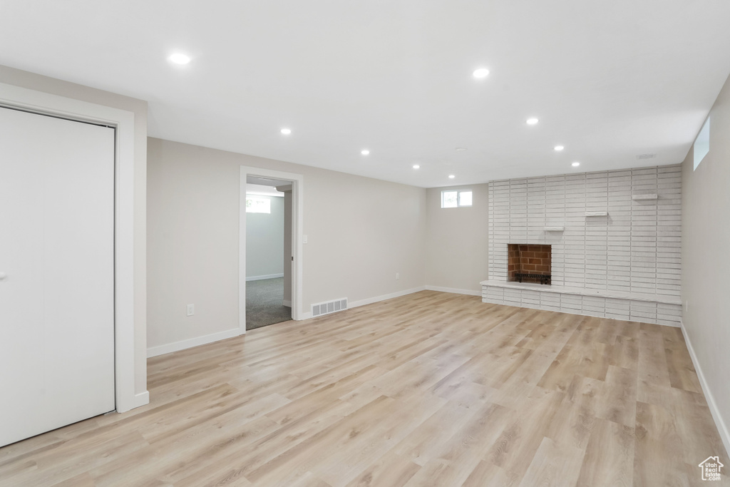 Unfurnished living room with a fireplace and light hardwood / wood-style flooring