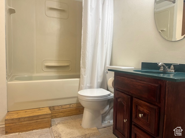 Full bathroom with toilet, vanity, and shower / bathtub combination with curtain