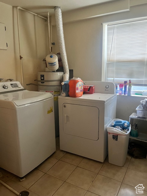 Laundry room with separate washer and dryer and light tile patterned floors