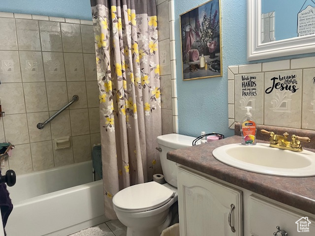 Full bathroom featuring tile patterned floors, toilet, shower / bath combo with shower curtain, and vanity