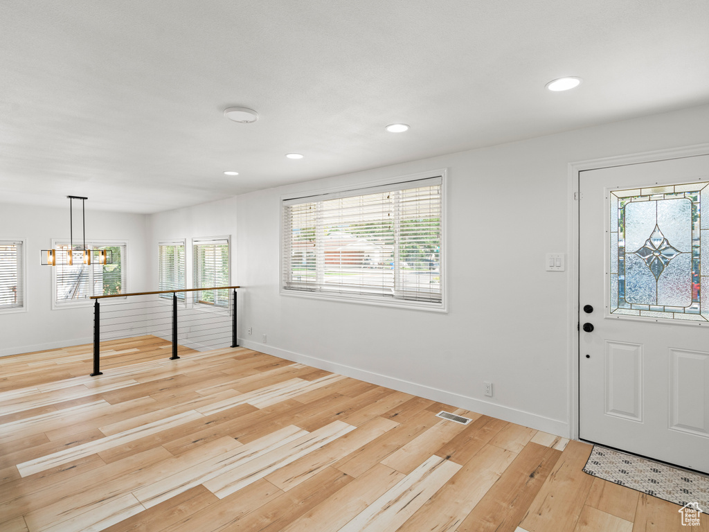 Entryway with light hardwood / wood-style flooring and a chandelier