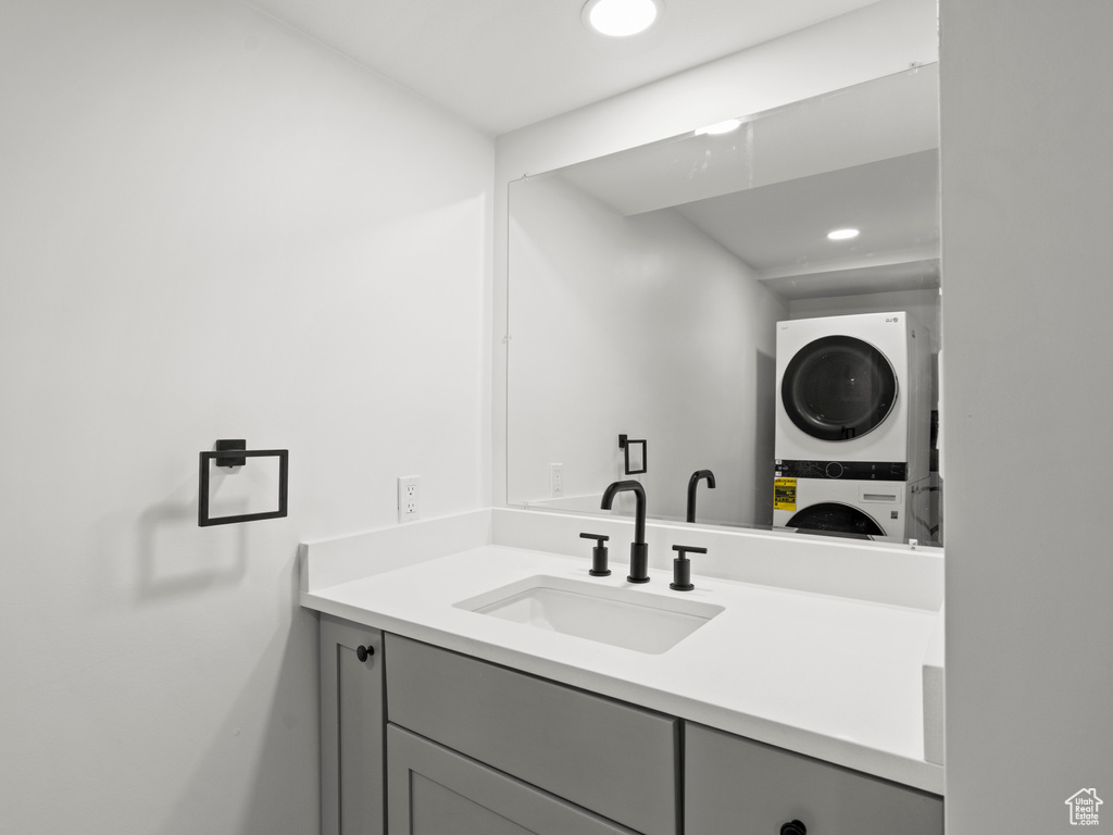 Bathroom with stacked washing maching and dryer and vanity