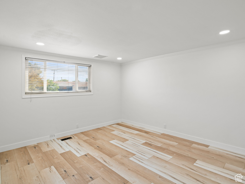 Unfurnished room featuring light hardwood / wood-style floors and crown molding