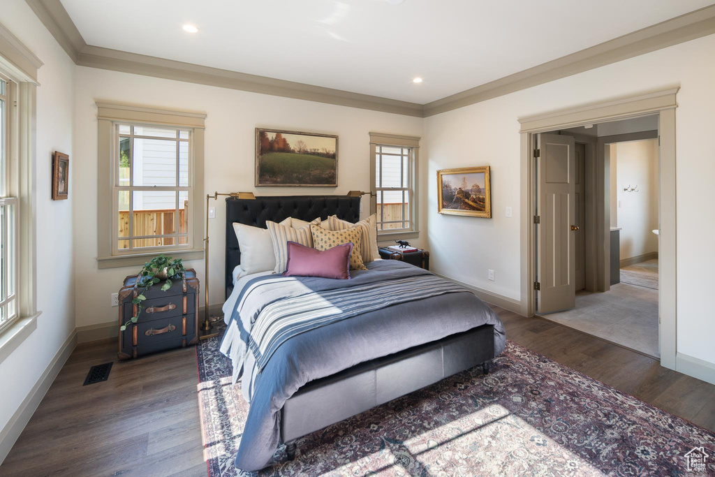 Bedroom featuring multiple windows, ornamental molding, and hardwood / wood-style flooring