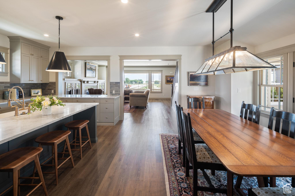 Dining room with sink and dark wood-type flooring