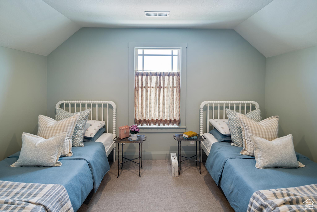 Bedroom featuring carpet flooring and lofted ceiling