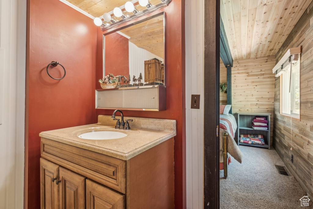 Bathroom with wooden walls, vanity, and wooden ceiling