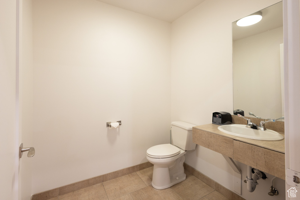 Bathroom featuring sink, toilet, and tile patterned floors