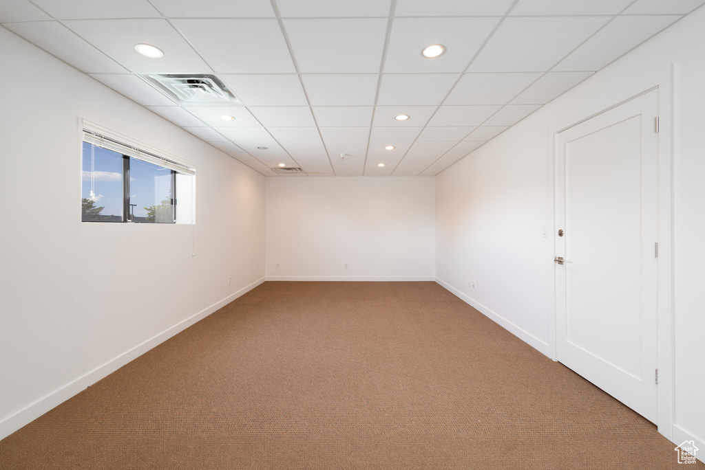 Unfurnished room with a paneled ceiling and carpet flooring