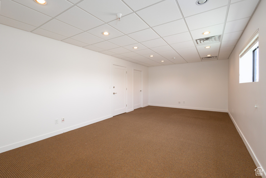 Empty room with a drop ceiling and carpet floors