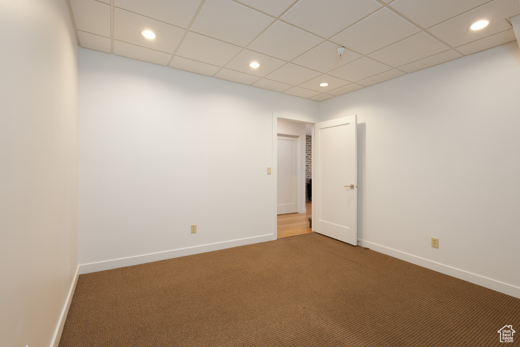 Empty room with carpet flooring and a paneled ceiling