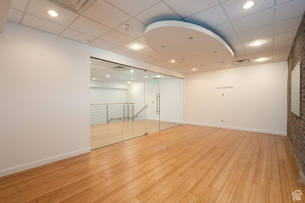 Spare room featuring light hardwood / wood-style floors and a drop ceiling