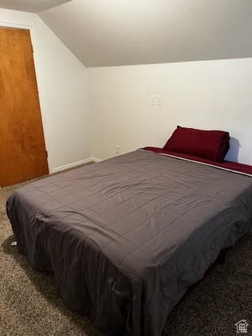 Carpeted bedroom featuring vaulted ceiling