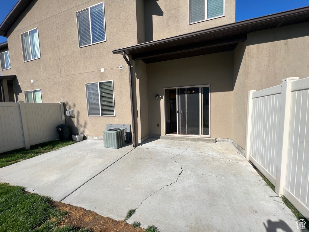 Back of house with a patio area and central air condition unit