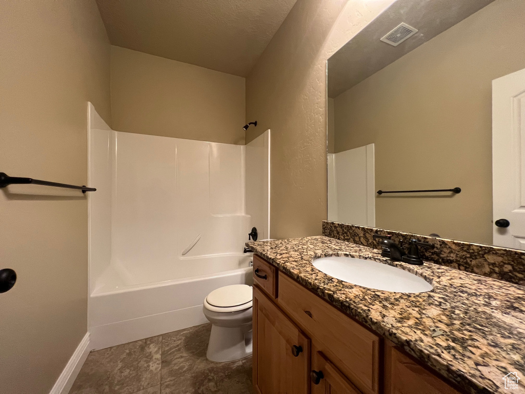 Full bathroom featuring vanity, toilet, shower / washtub combination, and a textured ceiling