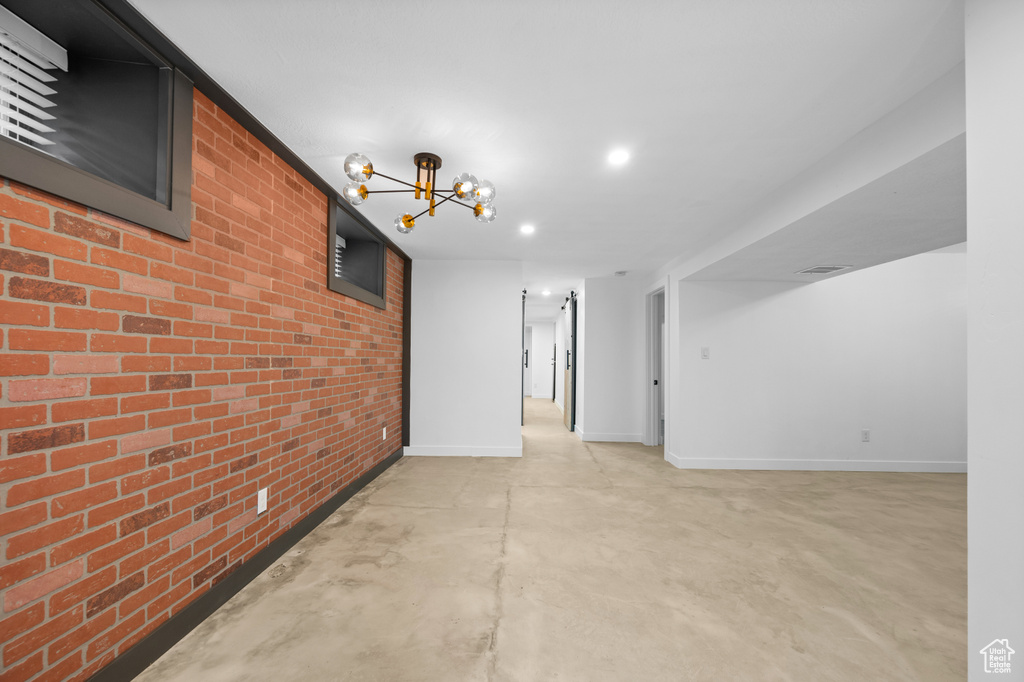 Unfurnished room with brick wall and an inviting chandelier