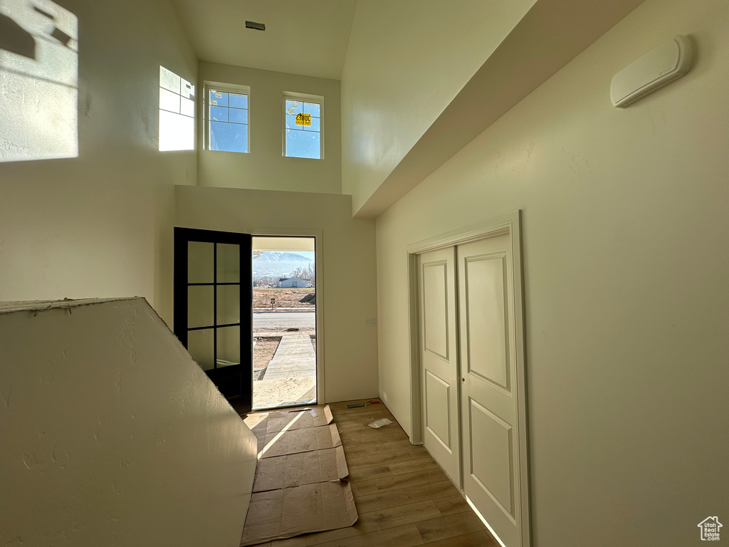 Interior space featuring hardwood / wood-style floors, a healthy amount of sunlight, a towering ceiling, and french doors