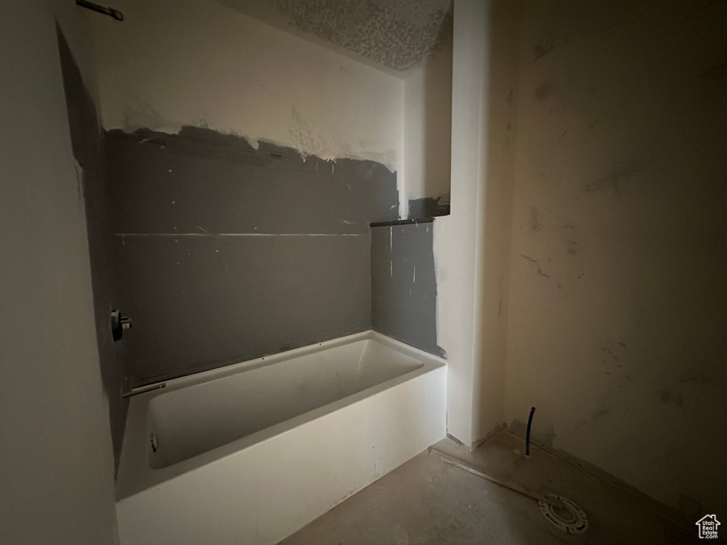 Bathroom featuring concrete flooring and a washtub