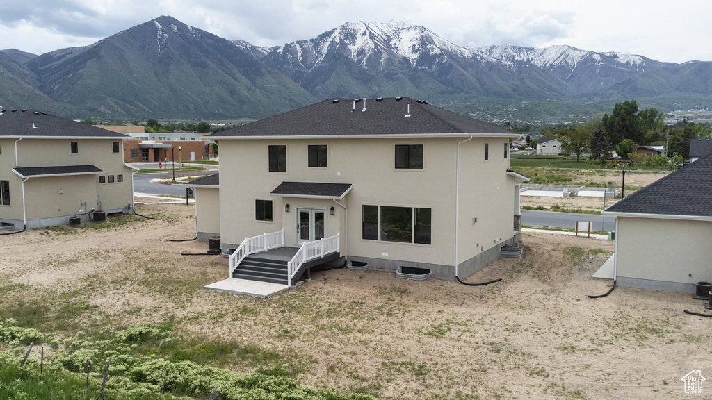 Back of property featuring a mountain view and stucco siding