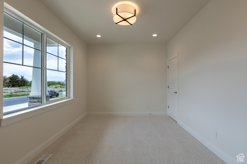 Spare room with recessed lighting, light carpet, and baseboards
