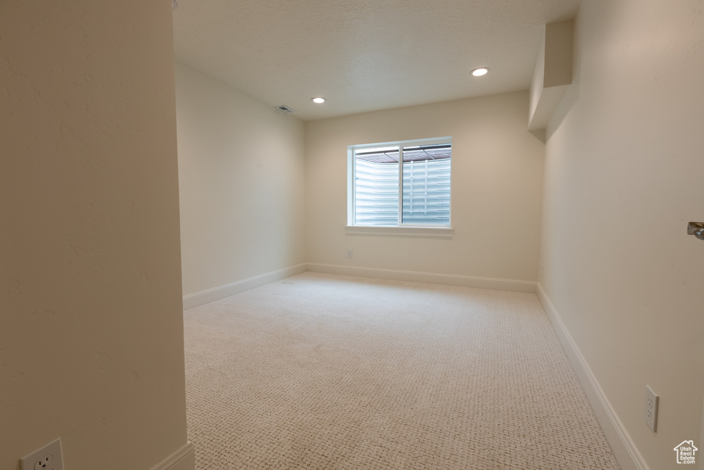 Spare room featuring carpet, recessed lighting, and baseboards