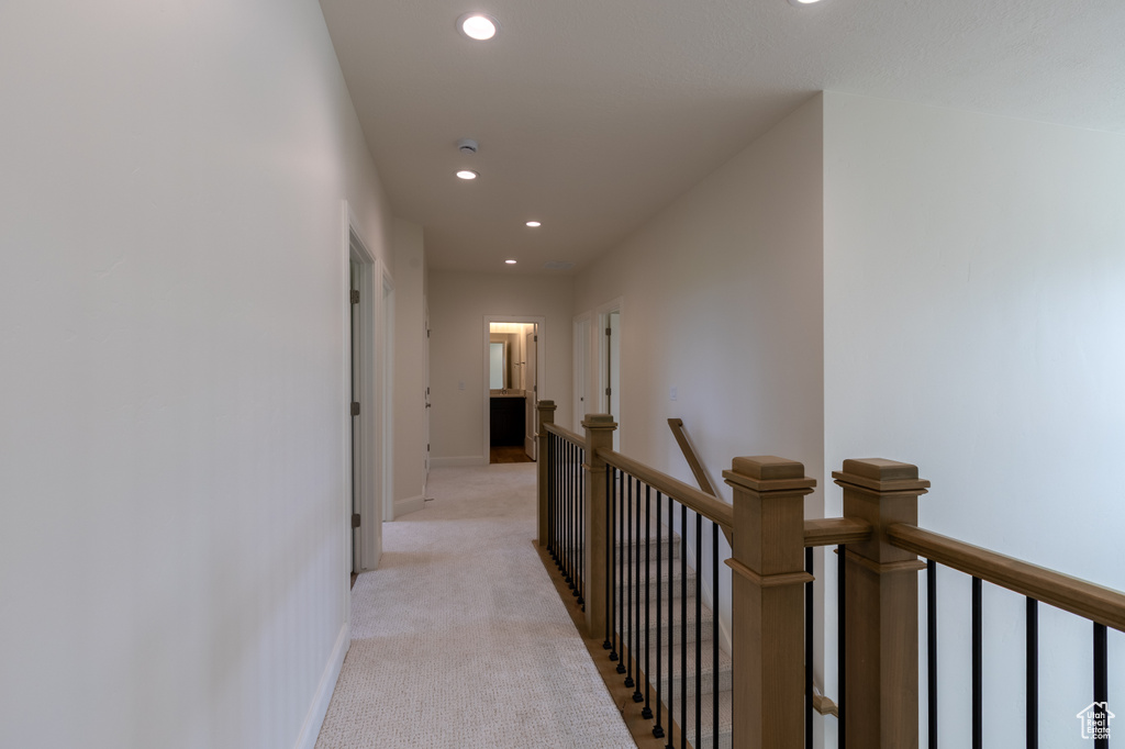 Corridor featuring an upstairs landing, recessed lighting, light carpet, and baseboards