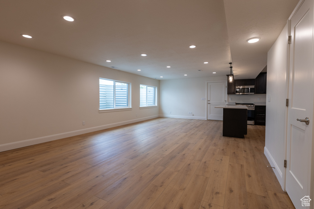 Unfurnished living room with recessed lighting, baseboards, and light wood-style flooring