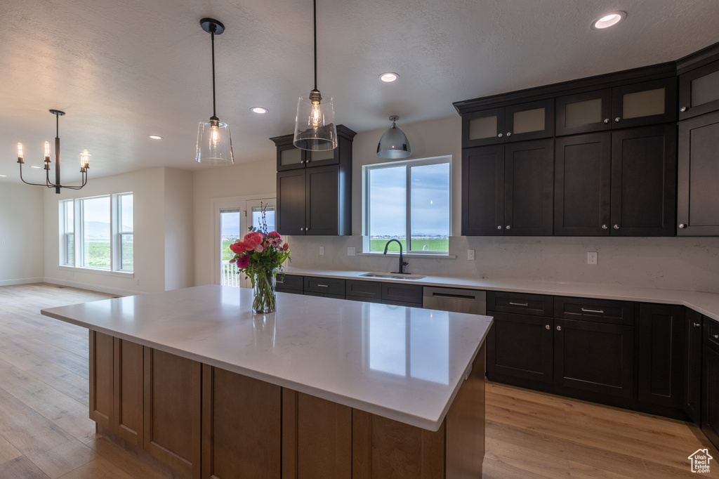 Kitchen with a sink, light wood-style floors, a center island, recessed lighting, and light countertops