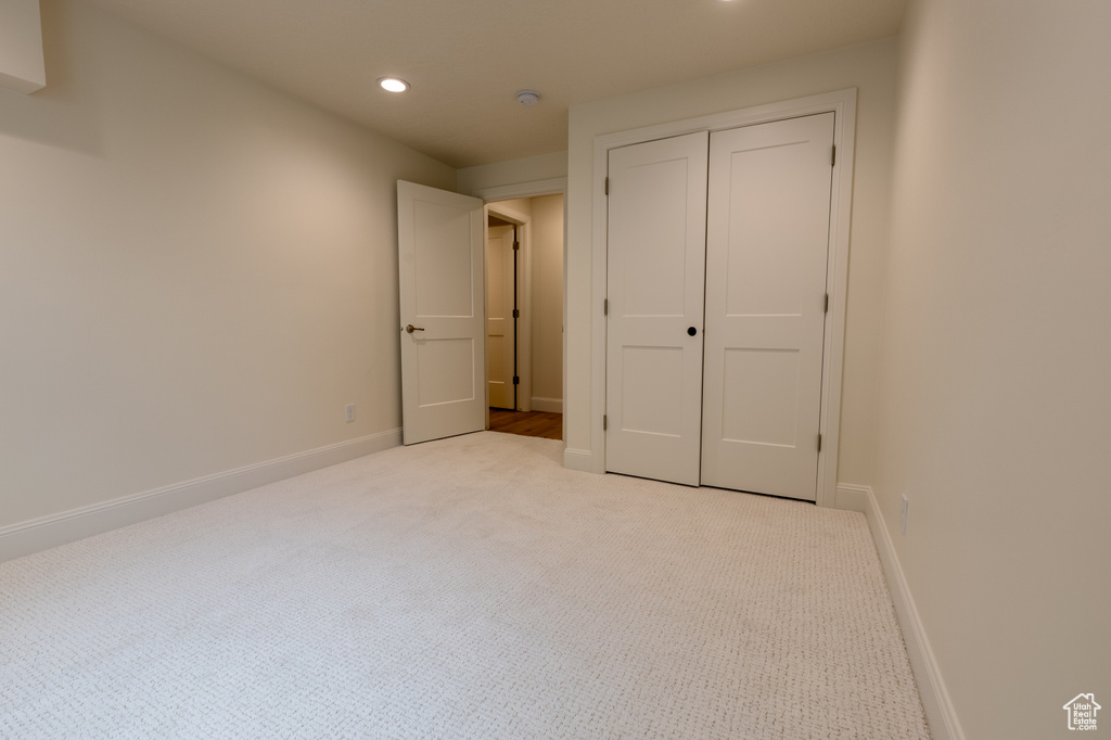 Unfurnished bedroom featuring carpet floors, recessed lighting, baseboards, and a closet
